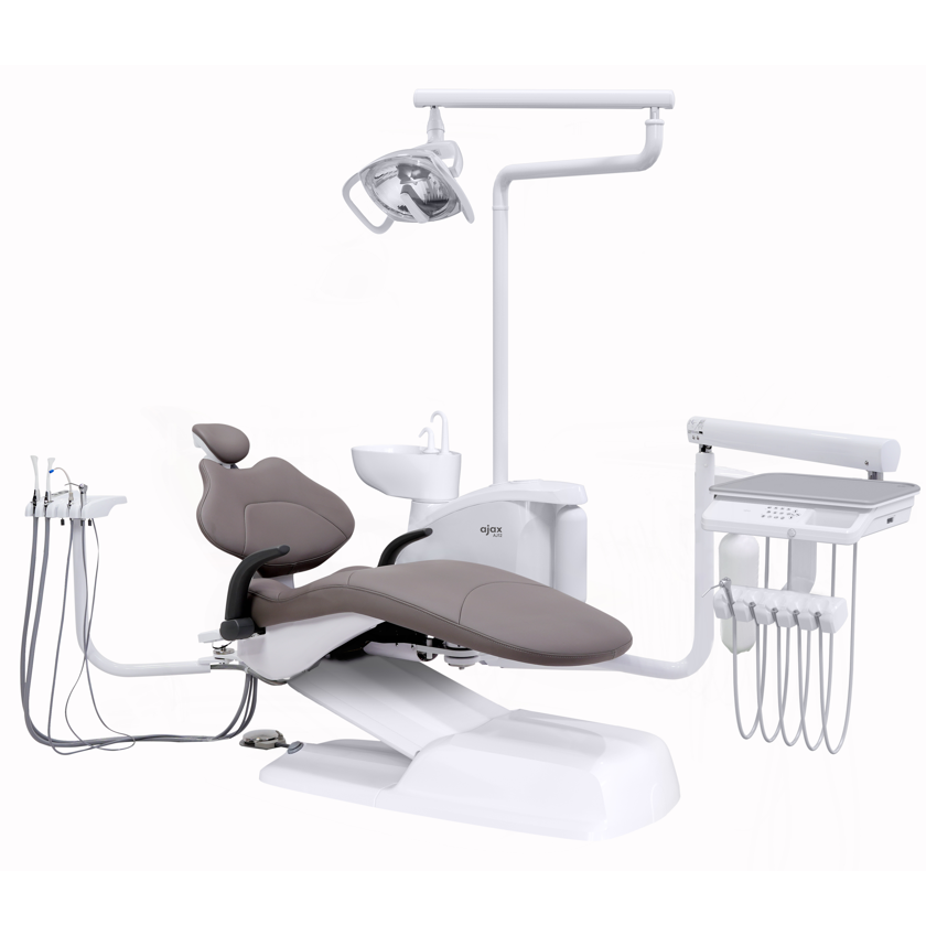 A modern dental operatory equipment set including a white dental chair with gray upholstery, an overhead light arm, a sink, and a treatment table accessory tray, shown on a plain white background.