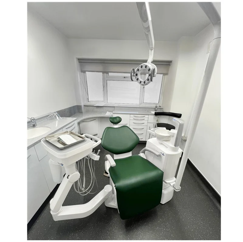 A Belmont white and dark green dental chair with an attached dental operatory console, dental arm, and overhead surgical light in a clean clinic room.