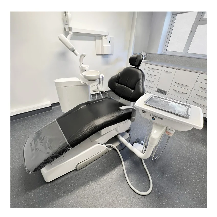 Belmont Voyager 2 white and black dental chair in a clean dental clinic room with cabinets, a sink, and an overhead light.